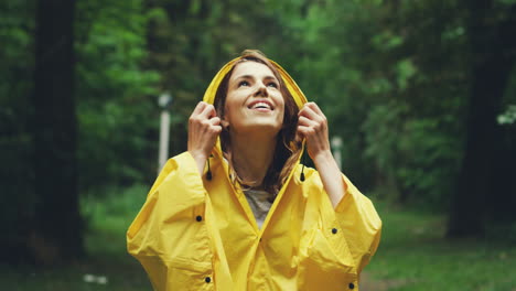 close up of abeautiful woman in a yellow raincoat standing in the middle of the forest