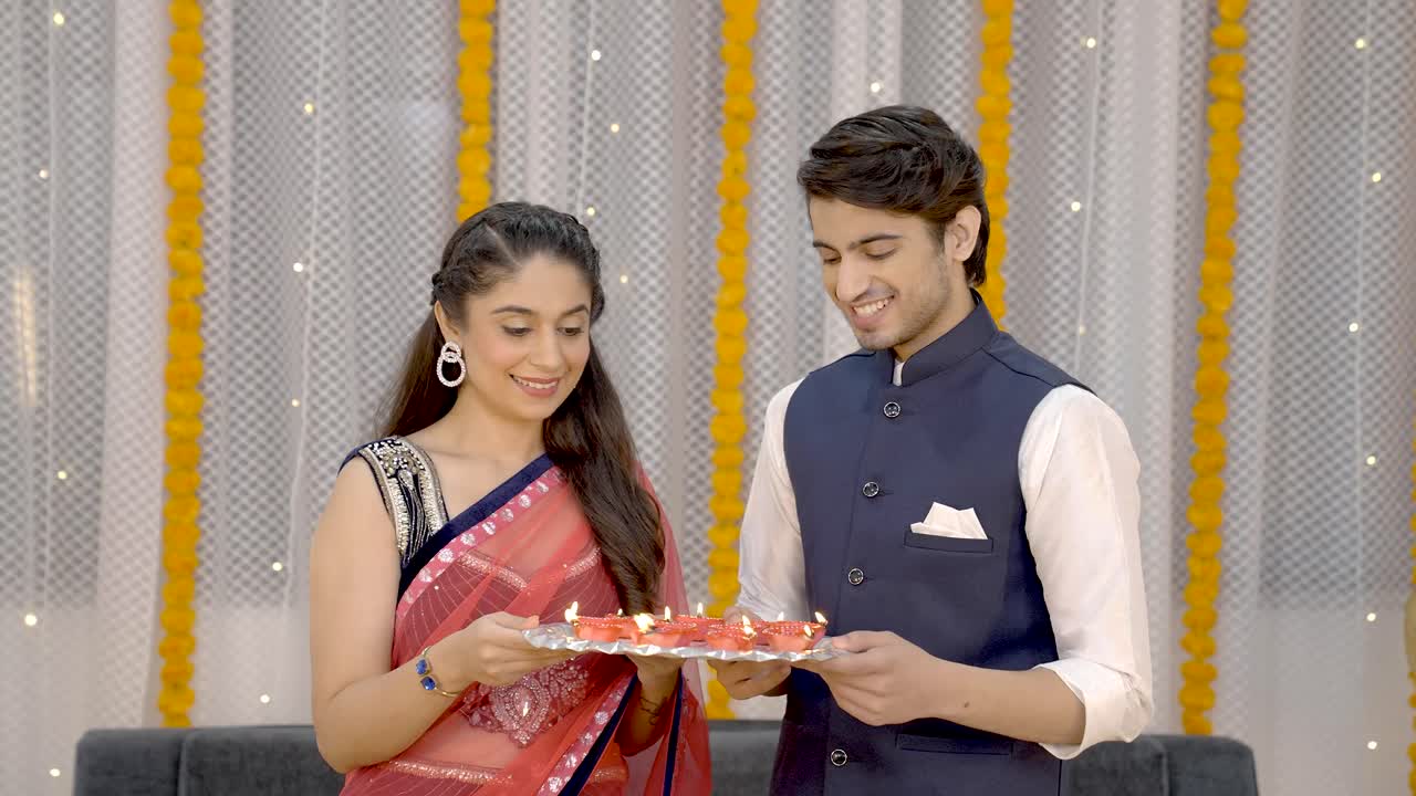 pareja india sosteniendo a diye en diwali
