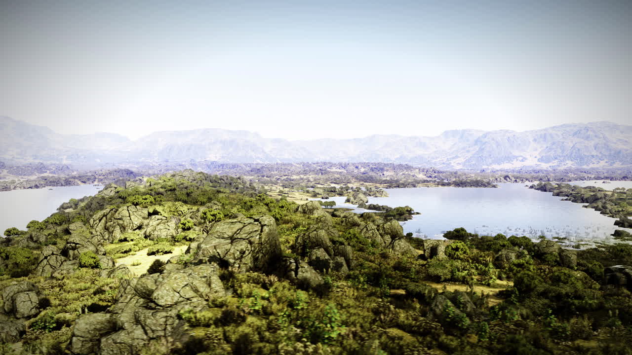 Paesaggio verde lussureggiante con formazioni rocciose e laghi sereni alla luce del giorno.