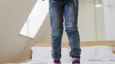 young boy bouncing on bed