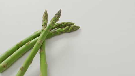 video of close up of fresh asparagus with copy space over white background