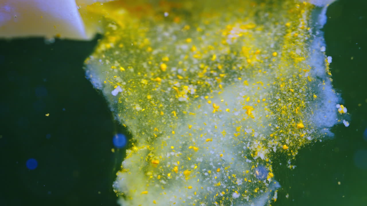 Pill dissolving in liquid, creating a colorful mix of bubbles and particles