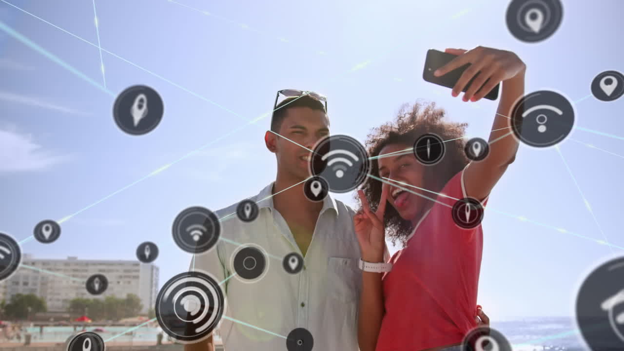 red de iconos digitales contra una pareja biracial tomando una selfie desde un teléfono inteligente
