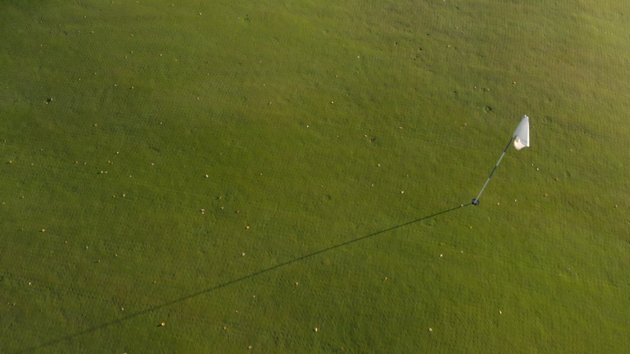 движение над и мимо белого флага на зеленом поле для гольфа