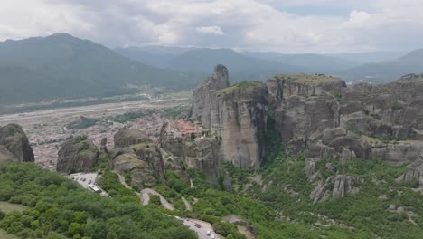 Wide-aerial-arcing-shot-of-Holy-Trinity-monastery-atop-rock-column,-Meteora