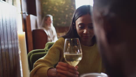 Primer-Plano-De-Una-Reunión-De-Pareja-Para-Tomar-Una-Copa-A-La-Hora-Del-Almuerzo-En-Un-Pub-Inglés-Tradicional-Haciendo-Un-Brindis