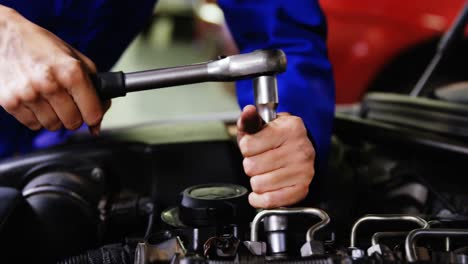 manos de una mecánica que hace servicio a un coche