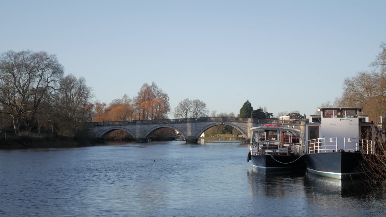 A calm river scene with boats and the Richmond Road Bridge on a clear autumn day