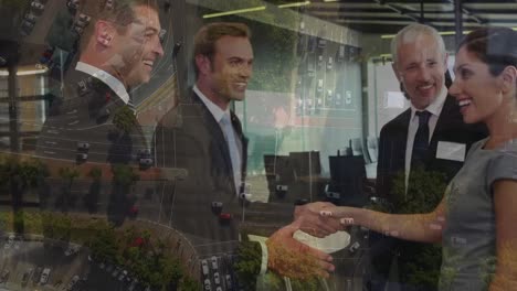 digital composition of diverse businesspeople shaking hands at office over aerial view of cityscape