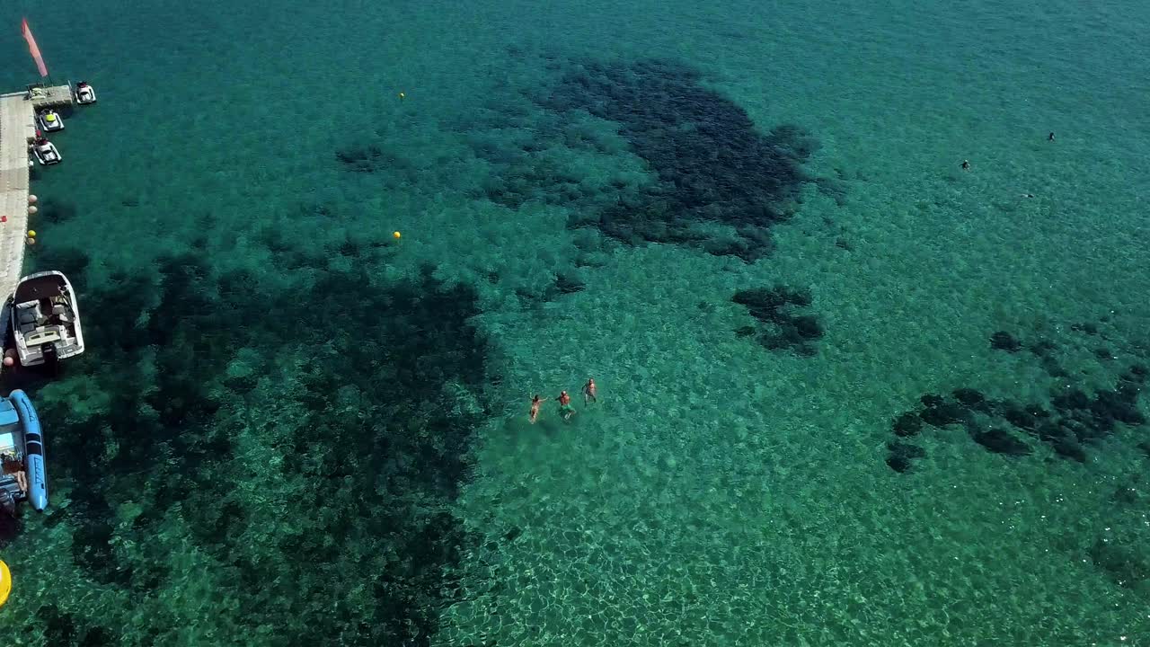 지중해의 맑은 청록색 물로 드론 촬영, 카메라가 올라가고 사람들이 수영