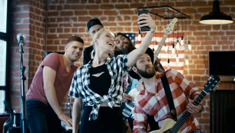 cheerful musicians taking selfie on stage