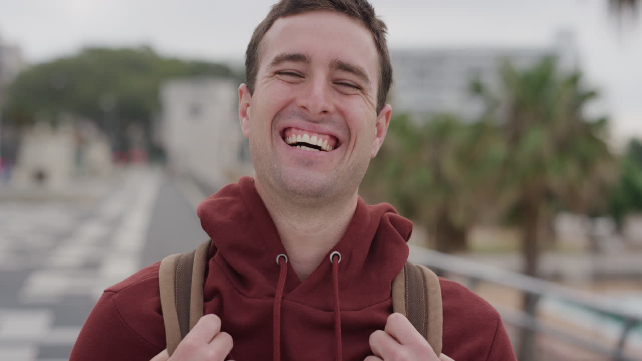 retrato joven atractivo riendo disfrutando de unas vacaciones exitosas estilo de vida independiente estudiante masculino viaje de verano en la ciudad urbana fondo costero cámara lenta