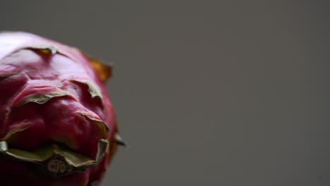 Panorámica-De-Dos-Frutas-Del-Dragón-Rojo-Sentadas-En-La-Mesa-Fruta-Del-Dragón-Blanco-Rodajas-De-Fruta-Del-Dragón-Rojo-Y-Cultivo-De-Plantas-Exóticas-Pitaya