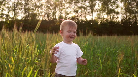 Niño-Con-Camisa-Blanca-Caminando-En-Un-Campo-Directamente-Hacia-La-Cámara-Y-Sonriendo-En-Un-Campo-De-Púas