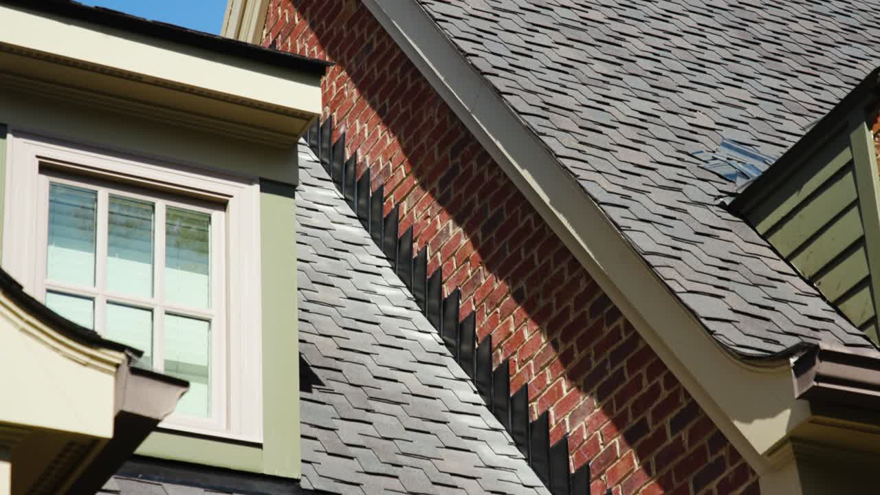 Tilt-up shot highlighting the transition from roof to brick and the clean seam on a new roof. Perfect for showcasing roofing and construction craftsmanship.