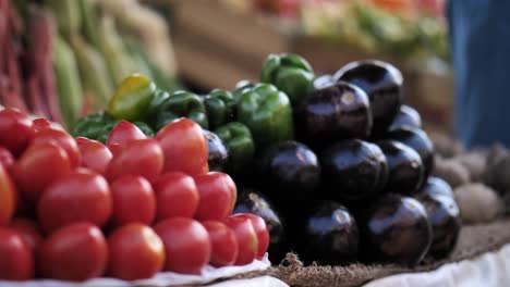 Pila-De-Tomates-Rojos-Frescos,-Pimientos-Verdes-Y-Berenjenas-En-El-Puesto-Del-Mercado