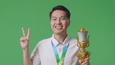 man holding a trophy and smiling