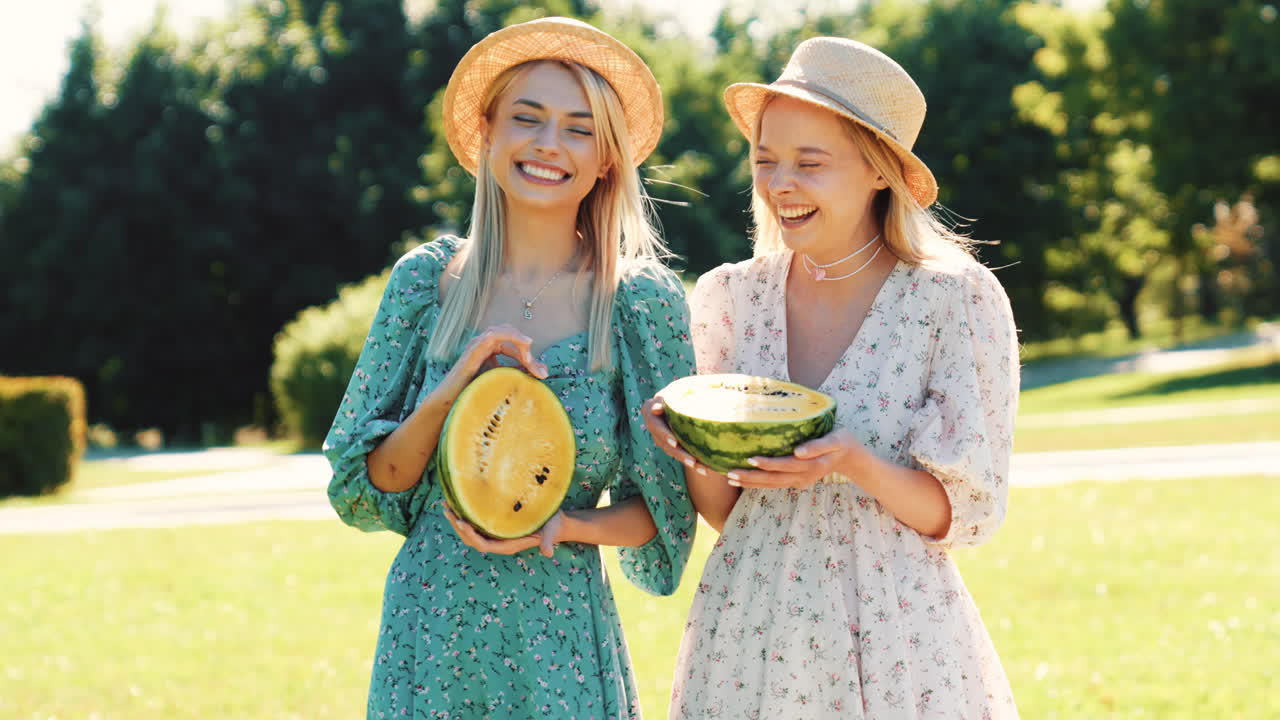 두 친구 가 공원 에서 수박 을 즐기고 있다