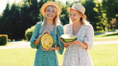 two friends enjoying watermelon in a park