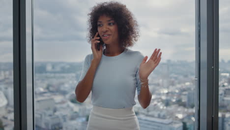 mujer de negocios afroamericana hablando en teléfono inteligente en la oficina