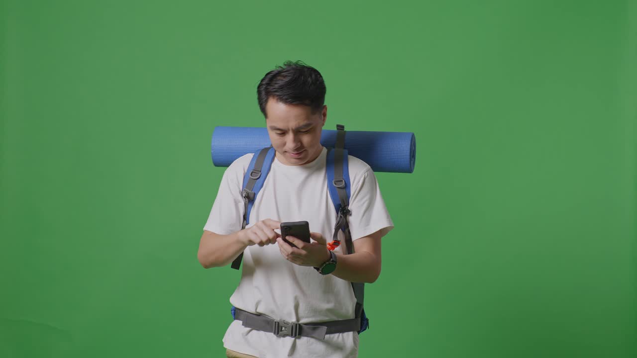 초록색 스크린에서 스마트폰을 사용하는 배을 가진 남자