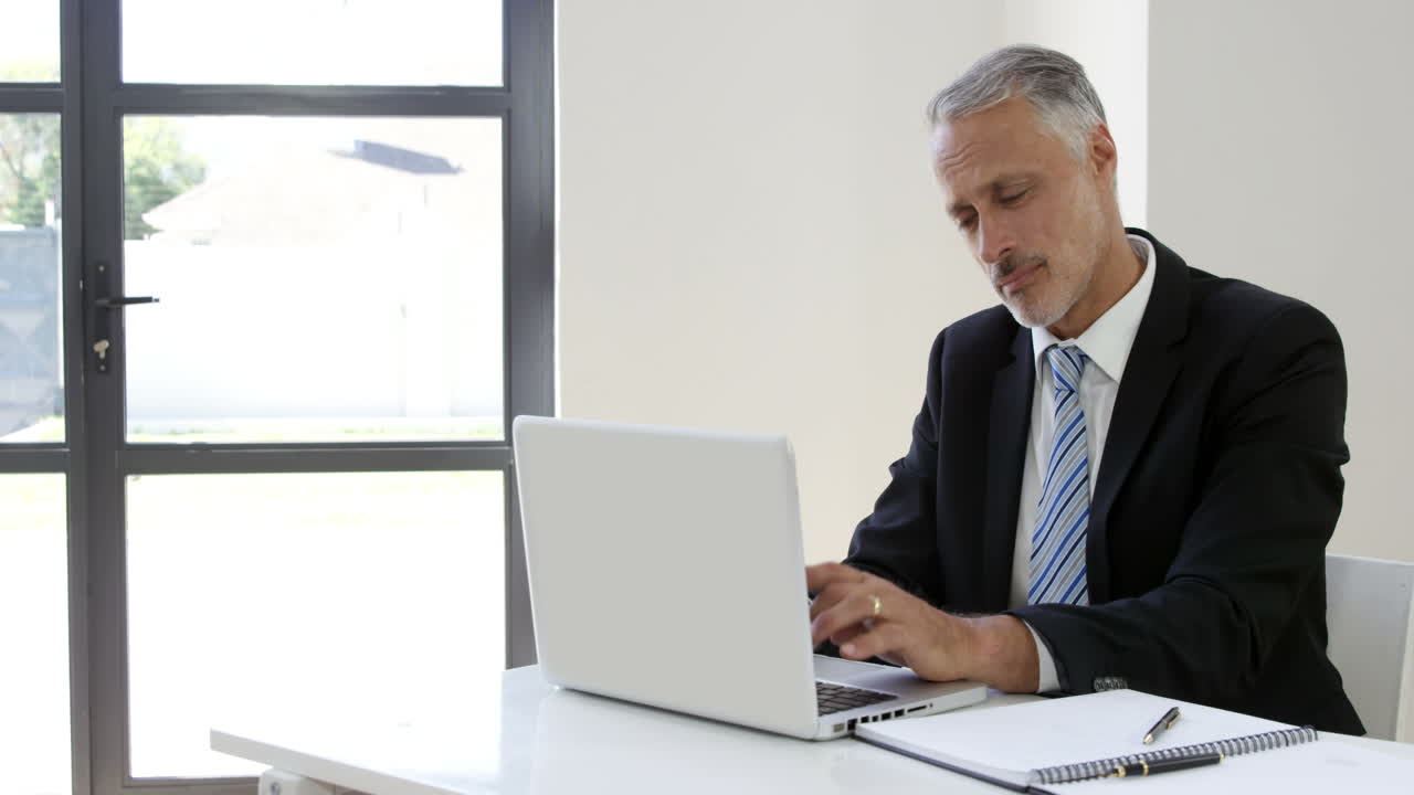 Seated businessman typing on his laptop