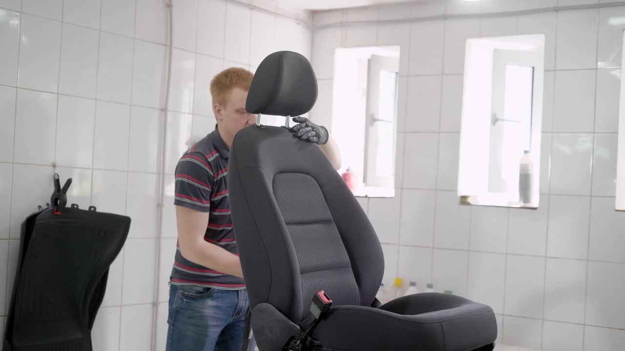 hombre lavando aspirador asiento de coche