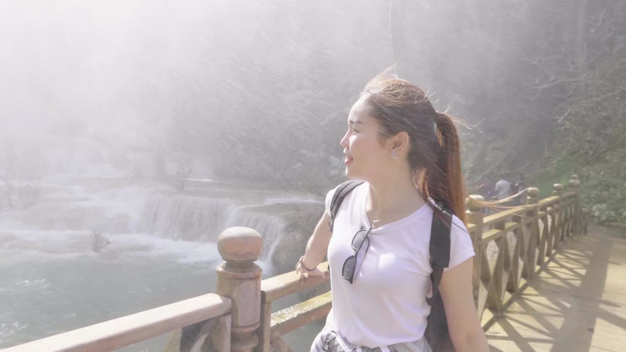 Tourist Woman Walking On Wooden Bridge Near Waterfall, Slow Motion