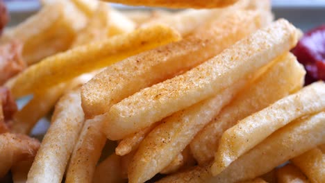 close-up of golden french fries with ketchup and spices