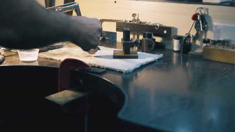 el joyero derrite metal en el crisol con un quemador de gas en la mesa
