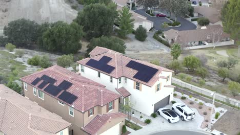 two neighborhood houses with solar panels, renewable energy concept, tesla model 3 in driveway, aerial