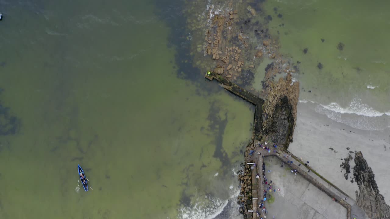 la parte superior aérea hacia abajo para inclinar hacia arriba de los barcos de currach que compiten frente a la costa de irlanda