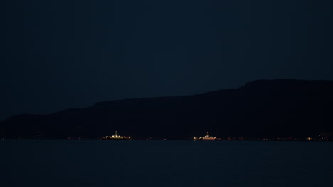 Two-ferry-boats-crossing-paths-at-night