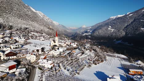 Pequeño-Pueblo-En-Invierno-Entre-Grandes-Montañas-Con-Nieve