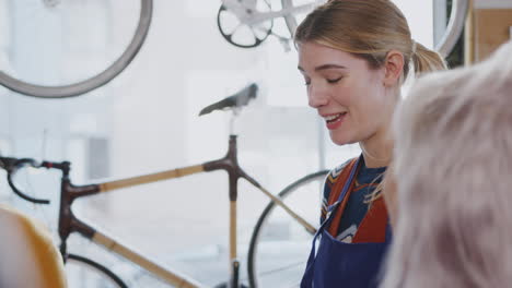 equipo de mujeres aprendices en un taller aprendiendo a ensamblar el marco de una bicicleta hecha a mano