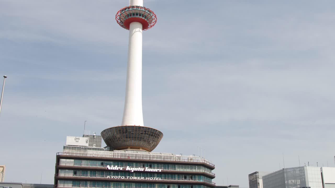 Bidikan lebar statis menara putih ikonik dan arsitektur perkotaan di Kyoto, Jepang.