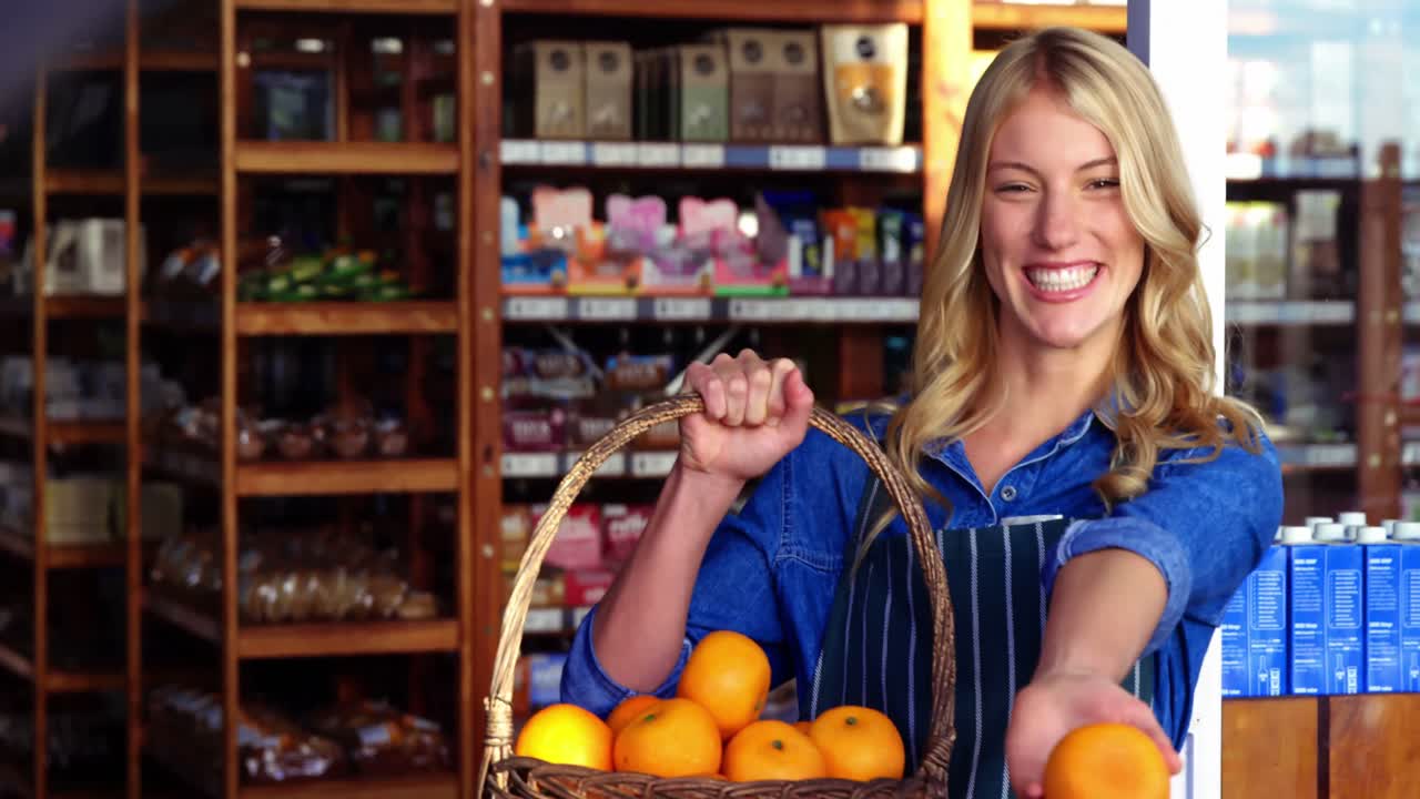 유기적 인 섹션 에서 과일 바구니 를 들고 있는 웃는 여성 직원 들