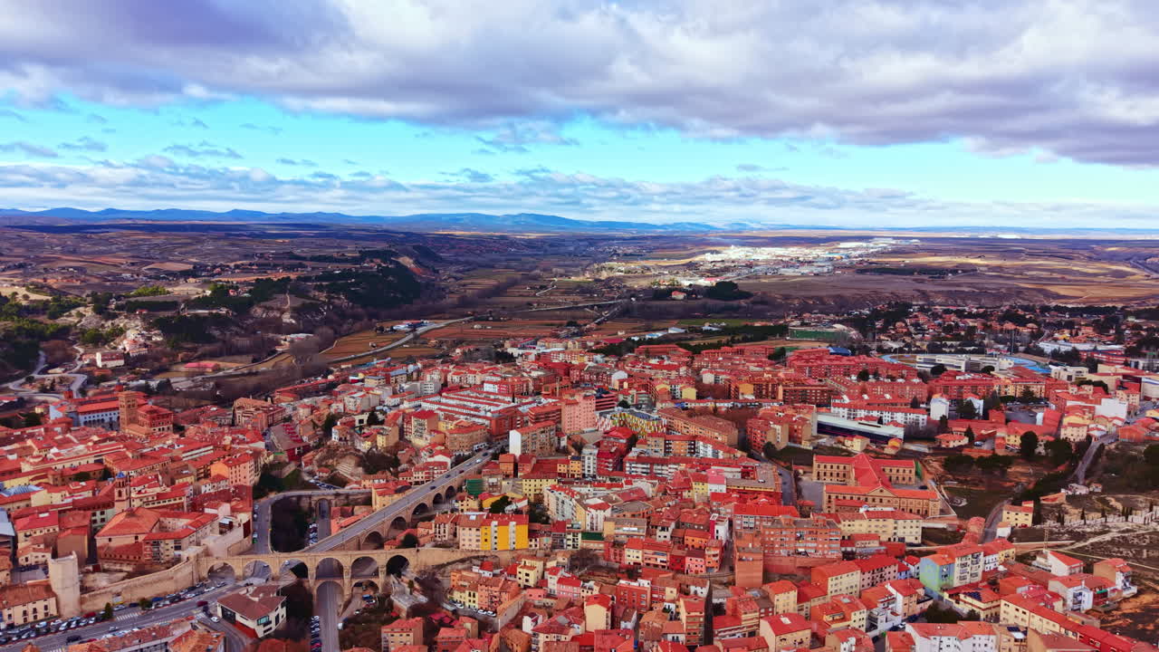Udsigt over en lille by i Spanien med røde tage, landskab og blå himmel, taget ovenfra om dagen med skyer på himlen