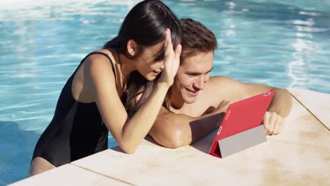 Entzückendes-Paar,-Das-Sein-Tablet-Am-Pool-Benutzt