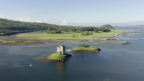 an aerial, high view of castle stalker on loch laich on a sunny morning