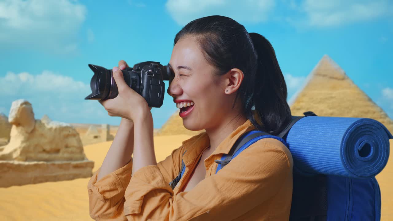 Close Up Side View Of Asian Female Hiker With Mountaineering Backpack Using A Camera Taking Picture While Traveling In Pyramid Of Giza
