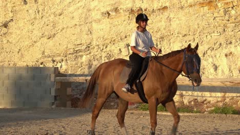 Ein-Junges-Mädchen,-Das-Lernt,-Ein-Pferd-In-Einem-Gehege-Zu-Reiten