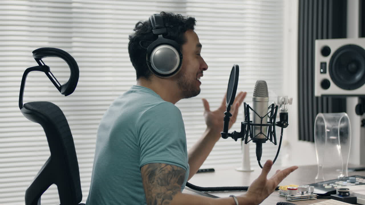 Talking into microphone while gesturing with hand in a modern studio setting