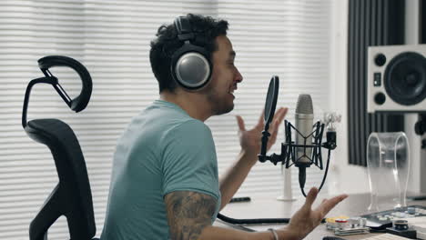 talking into microphone while gesturing with hand in a modern studio setting
