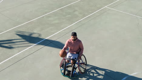 middle-aged man in sport wheelchair enjoying streetball game