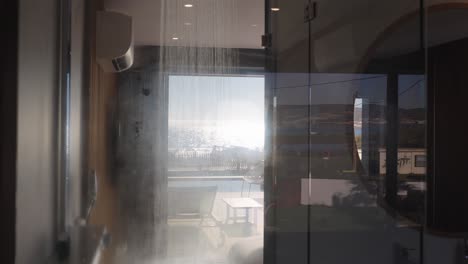 descending shot of a shower running with steam gathering on the glass