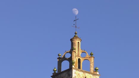 Moon-above-old-church-spire,-Spain