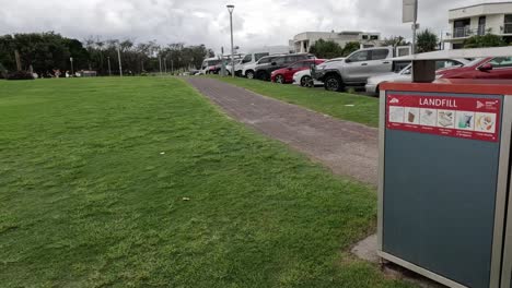 caminando hacia vertederos y contenedores de reciclaje en un parque