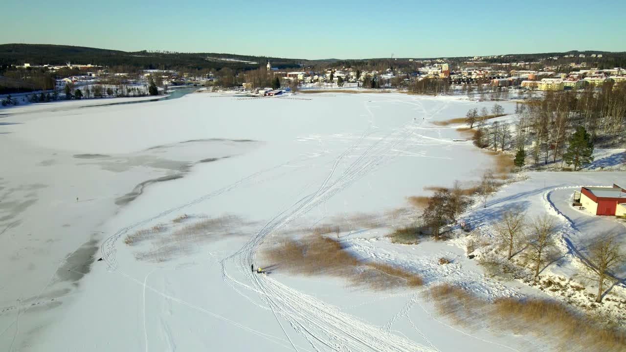개가 있는 가족이 춥고 화창한 날 얼어붙은 호수 위를 걷고 있다