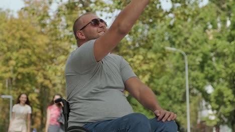 man with disabilities in wheelchair at the park alley use a smartphone